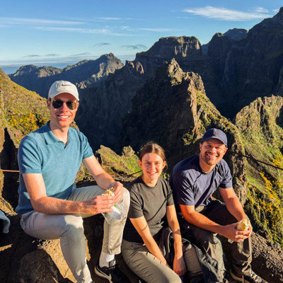 Jonge reizigers pauzeren tijdens een bergwandeling op Madeira, met uitzicht op ruige bergtoppen.