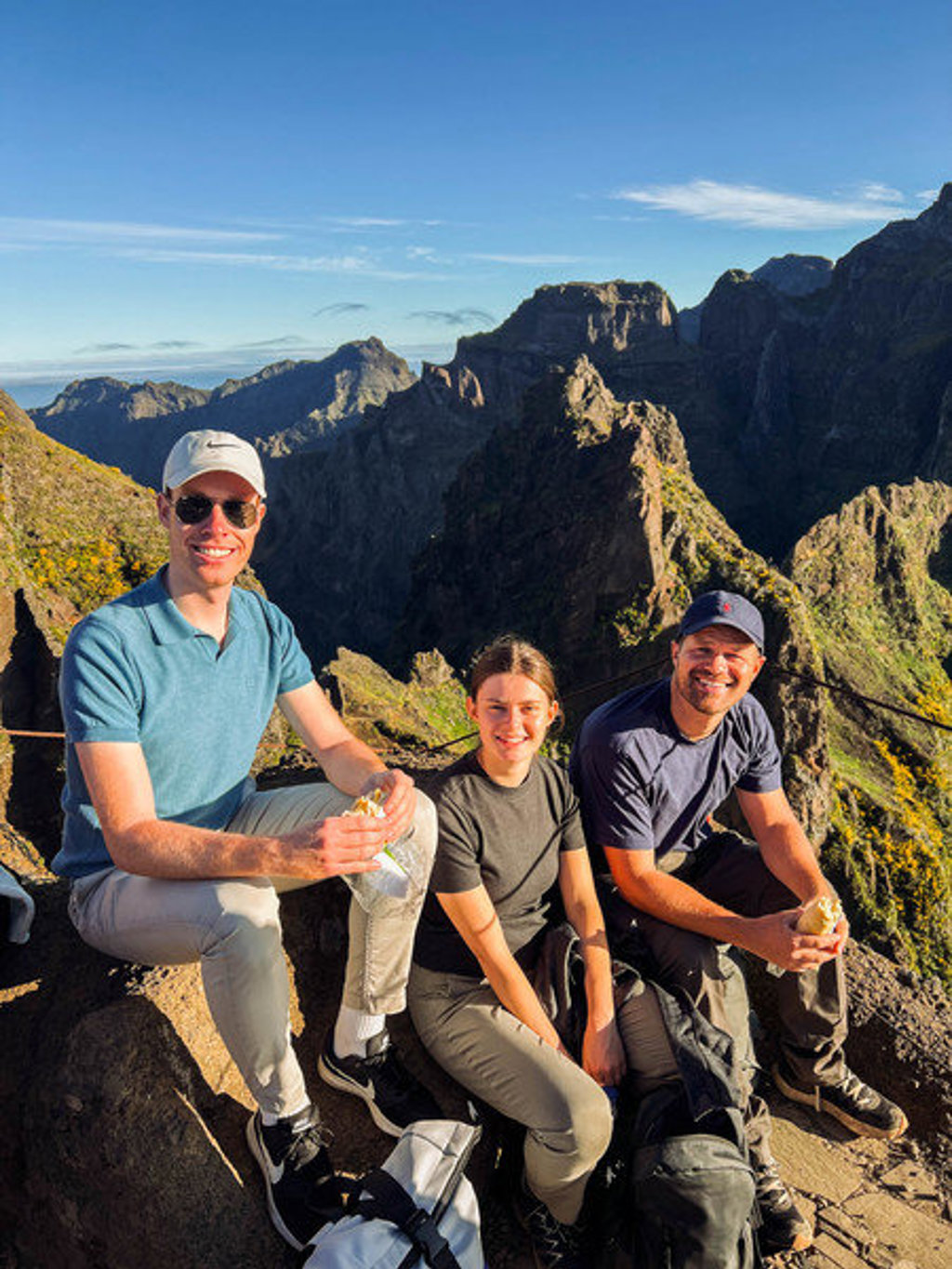 Jonge reizigers pauzeren tijdens een bergwandeling op Madeira, met uitzicht op ruige bergtoppen.