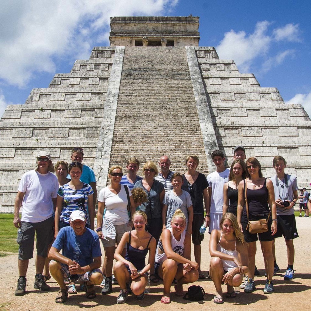 Familiegroep bij de piramide van Chichén Itzá tijdens familiereis Mexico.