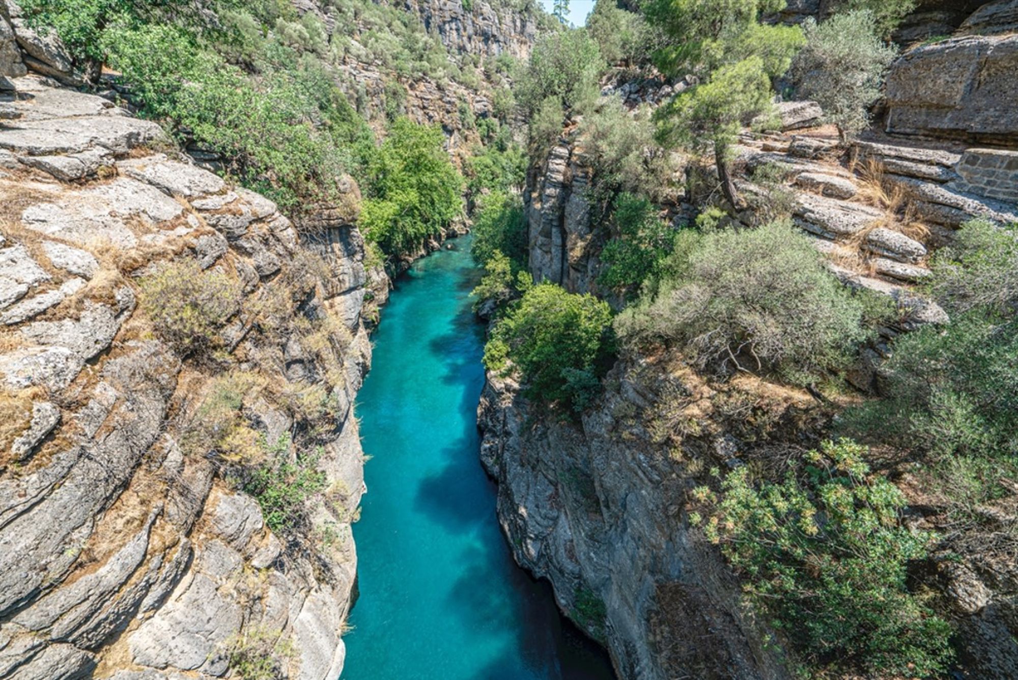 Turquoise rivier in een smalle kloof met rotswanden en groen, Turkije.