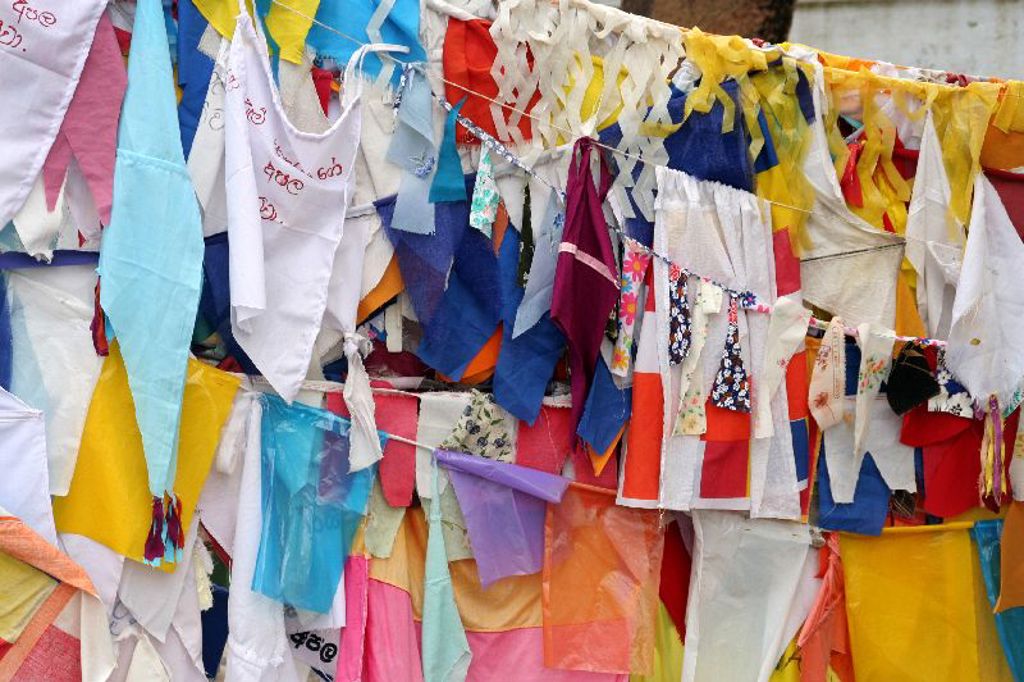 Kleurrijke gebedsvlaggen bij een boeddhistische tempel tijdens een familiereis in Sri Lanka.