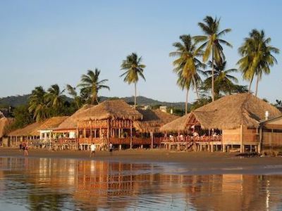 Strand met palmbomen en rieten strandhutten tijdens de route Costa Rica en Nicaragua.