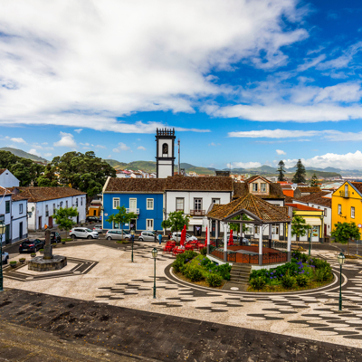 Centraal plein in Ribeira Grande op São Miguel, Azoren, met kiosk, kerk en kleurrijke huizen.