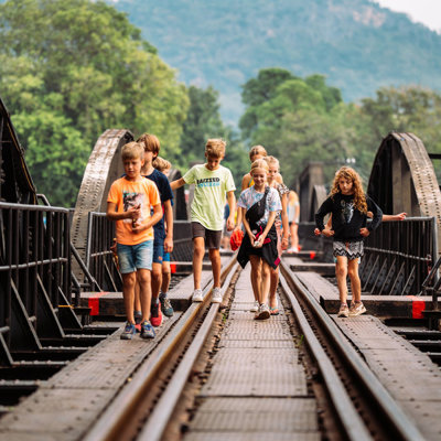 Kinderen wandelen over de spoorbrug bij de River Kwai in Thailand tijdens de Familiereis Thailand Chill & Adventure.