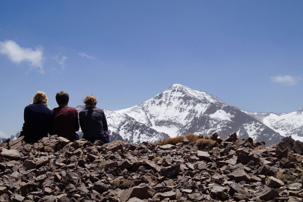 Wandelaars kijken uit op de besneeuwde top van Mount Toubkal tijdens een wandelvakantie in Marokko.