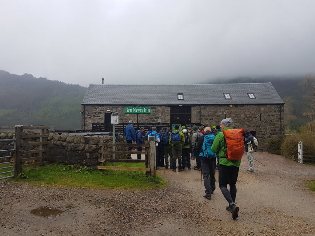Wandelaars met rugzakken bij de Ben Nevis Inn in de Schotse Hooglanden tijdens een groepsrondreis Schotland.