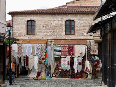 Marktkraam met kleurrijke tapijten en kantwerk in een oude bazaar in Albanië.