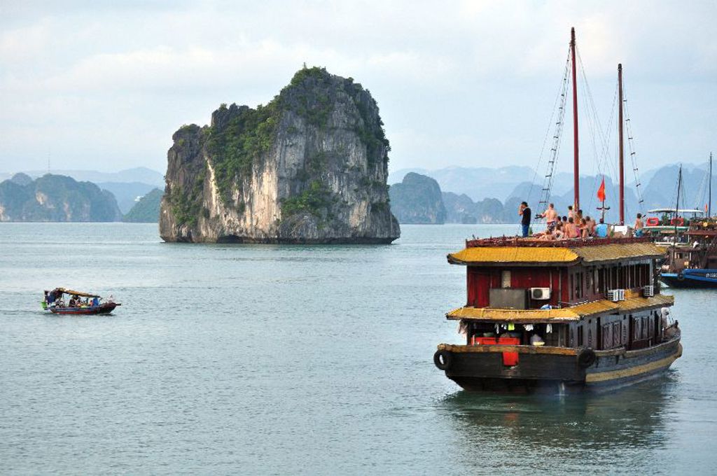 Cruiseboot in Halong Bay, Vietnam, langs kalkstenen rotsen tijdens 22-35ers groepsrondreis.