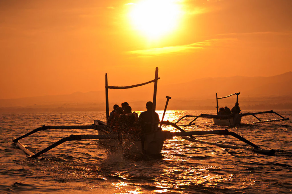 Traditionele vissersboten op zee bij zonsondergang in Indonesië tijdens groepsrondreis Java en Bali.
