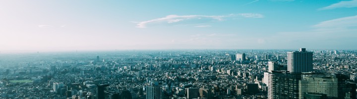 Panoramisch uitzicht over Shibuya en de skyline van Tokio onder een blauwe lucht.