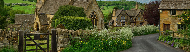 Cotswolds-dorp met stenen cottages en kerk langs wandelroute in het Verenigd Koninkrijk.