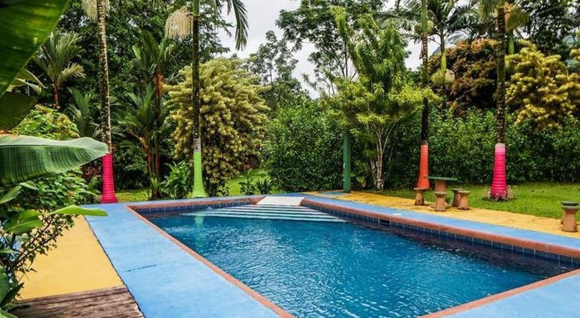 Zwembad in tropische tuin tussen palmbomen in Costa Rica.