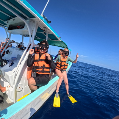Snorkelaars met duikmaskers en zwemvliezen stappen vanaf een boot de zee in tijdens een familiereis Mexico.