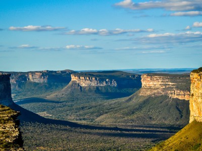 Uitzicht over de kliffen en tafelbergen van Chapada Diamantina in Brazilië onder een blauwe lucht.