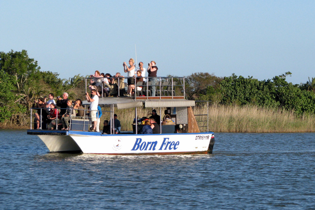 Safari-boot met reizigers die dieren spotten op het water tijdens een familiereis Zuid-Afrika en eSwatini.