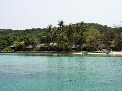 Tropisch strand met palmbomen en bootjes aan een rustige baai in Vietnam, Route Vietnam.