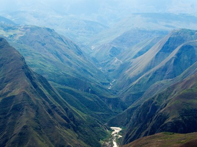 Uitzicht over een diepe groene vallei met rivier in Noord-Peru.