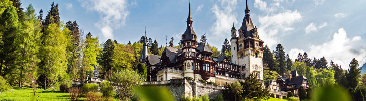 Kasteel Peleș in de Karpaten, Roemenië, omringd door bos en bergen.