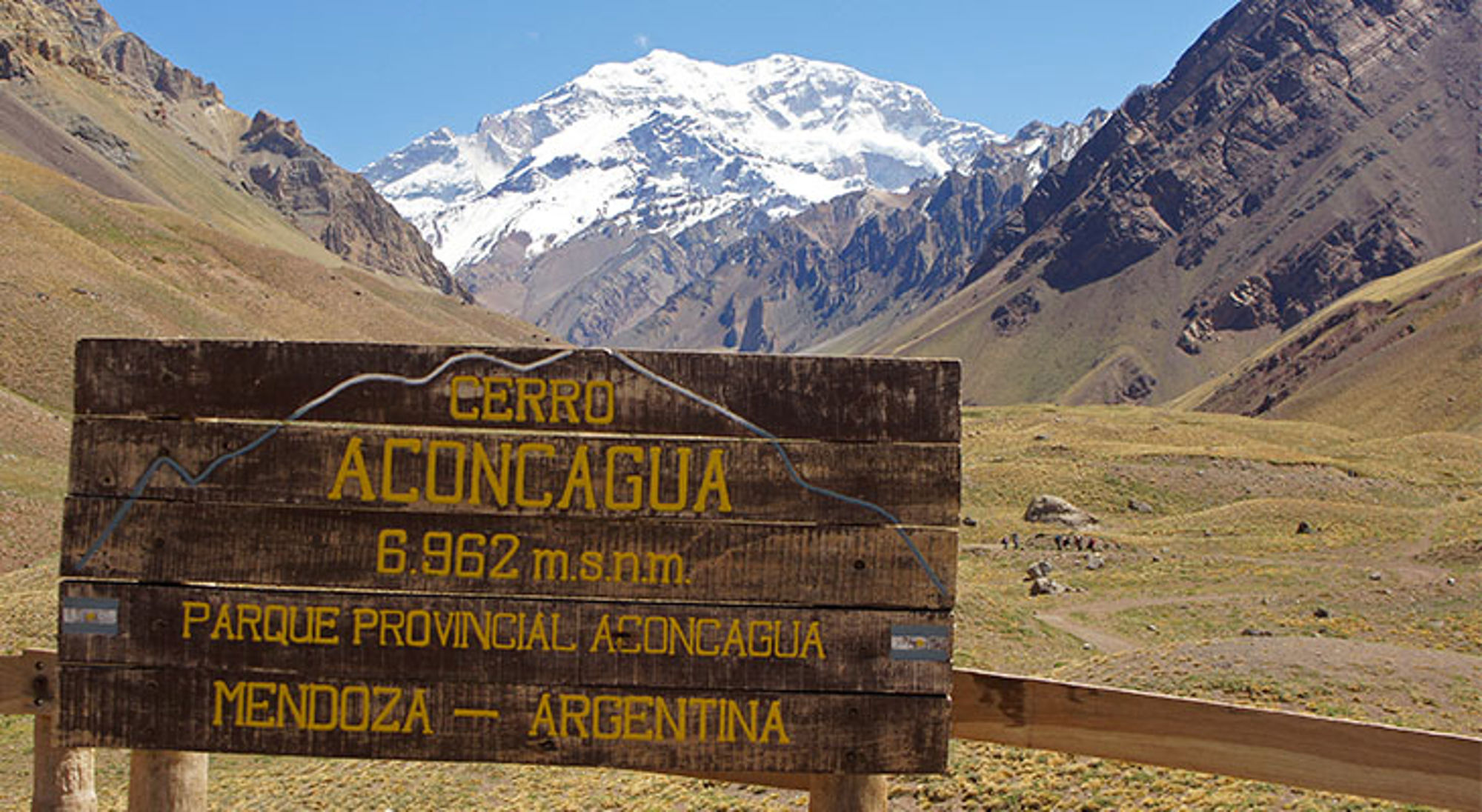 Houten bord bij Cerro Aconcagua (6.962 m) met besneeuwde bergtop in de Andes, Mendoza, Argentinië.