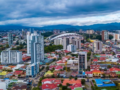 Skyline van San José, Costa Rica, met moderne hoogbouw en bergen op de achtergrond.