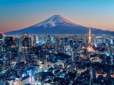Skyline van Tokio bij schemering met Tokyo Tower en de besneeuwde Mount Fuji op de achtergrond.
