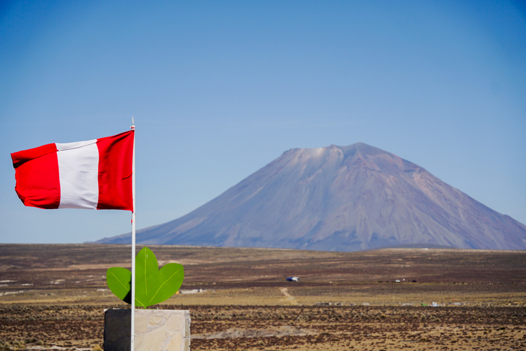 Peruaanse vlag met vulkaan op de achtergrond tijdens een 22-35ers groepsrondreis door Peru.