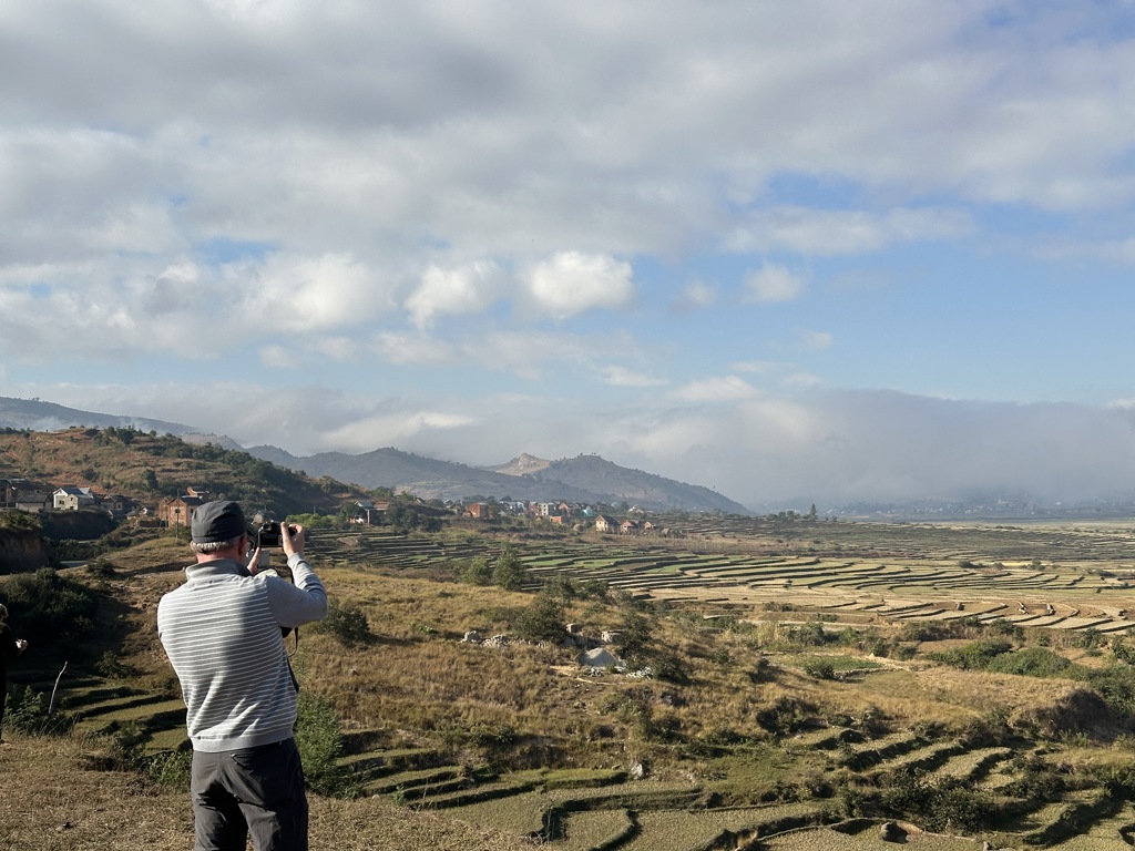 Reiziger fotografeert rijstterrassen en heuvels in Madagascar tijdens een groepsrondreis.