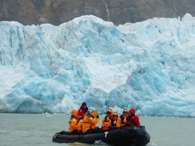 Zodiacboot met reizigers bij een gletsjerwand in Spitsbergen.