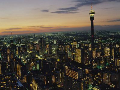 Avondzicht op de skyline van Johannesburg met de verlichte Hillbrow Tower.