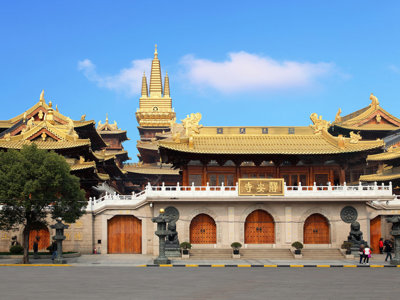 Jing’an-tempel in Shanghai met gouden daken en pagode tegen een blauwe lucht.