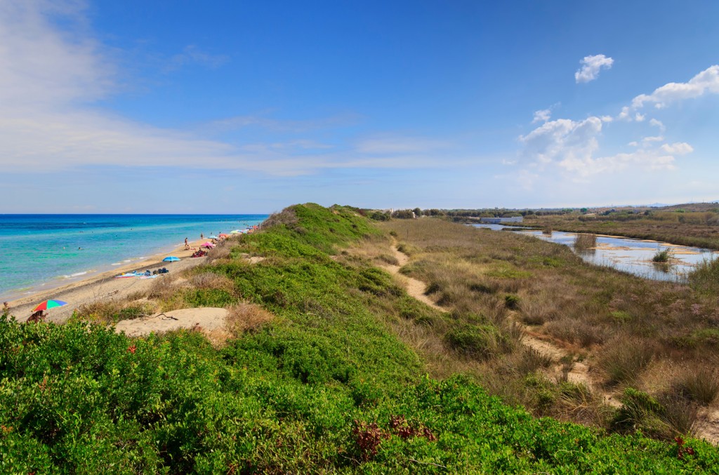 Duinlandschap met wandelpad langs het strand en kustlagune in Puglia, Italië.