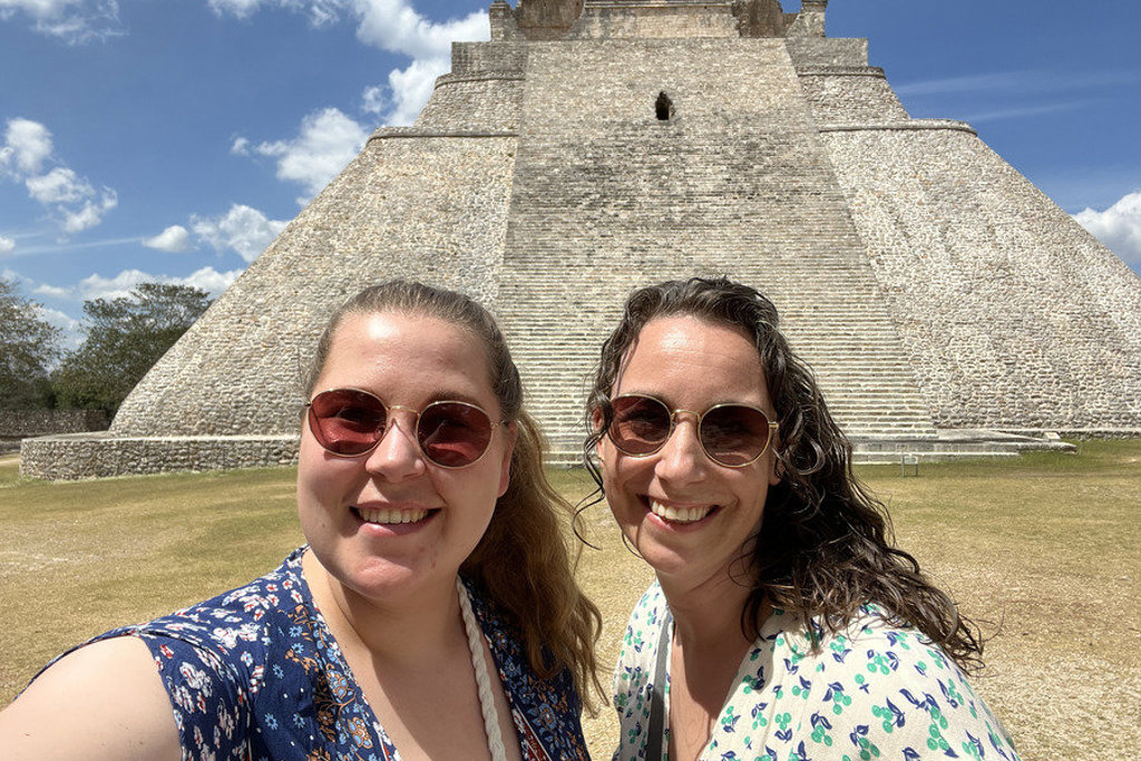 Reizigers poseren voor de Maya-piramide in Uxmal tijdens de 22-35ers groepsrondreis door Mexico.