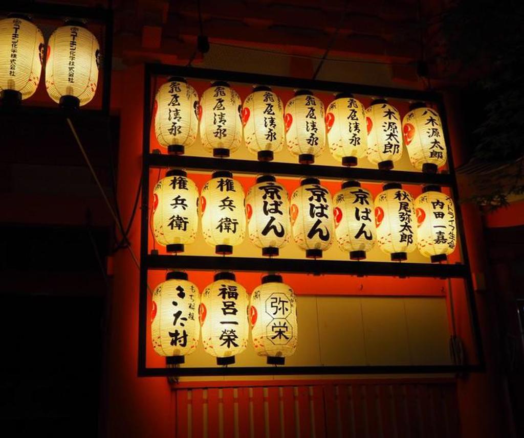 Japanse lantaarns met kalligrafie bij een tempel, sfeervol verlicht tijdens een groepsrondreis Japan.