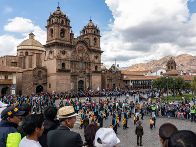 Drukke Plaza de Armas in Cusco met de kathedraal, tijdens een optocht op groepsrondreis Peru.