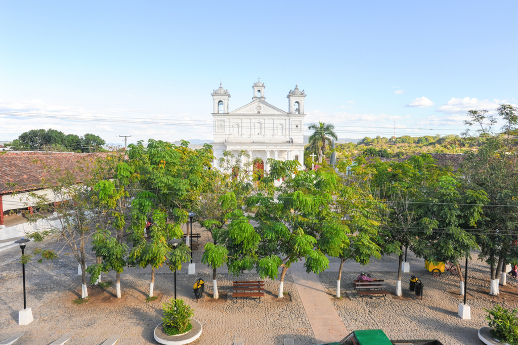 Witte kerk aan een groen plein in Copán Ruinas, Honduras, tijdens 22-35ers rondreis Guatemala, Honduras en El Salvador.