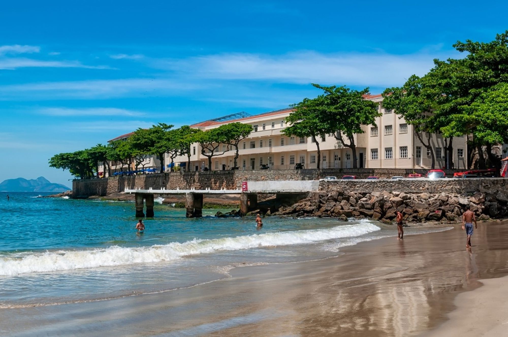 Strand van Flamengo in Rio de Janeiro met boulevard, bomen en gebouw aan zee.