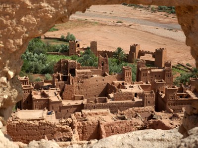 Uitzicht op de lemen kasbah Aït Ben Haddou in Marokko, gezien door een rotsopening.