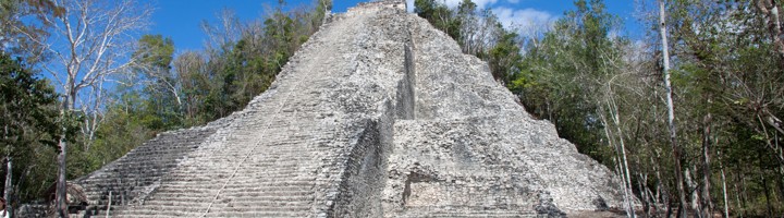 Nohoch Mul-piramide bij de Maya-ruïnes van Cobá, Mexico, omringd door jungle onder een blauwe lucht.