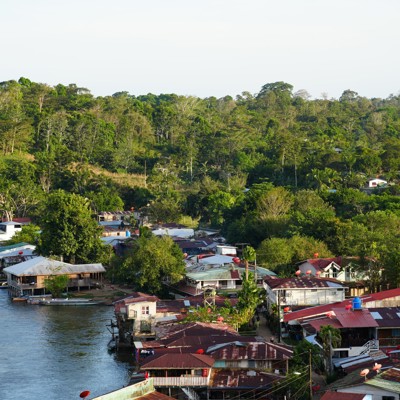 Huizen langs een rivier, omringd door groen regenwoud tijdens groepsrondreis Nicaragua en Costa Rica.
