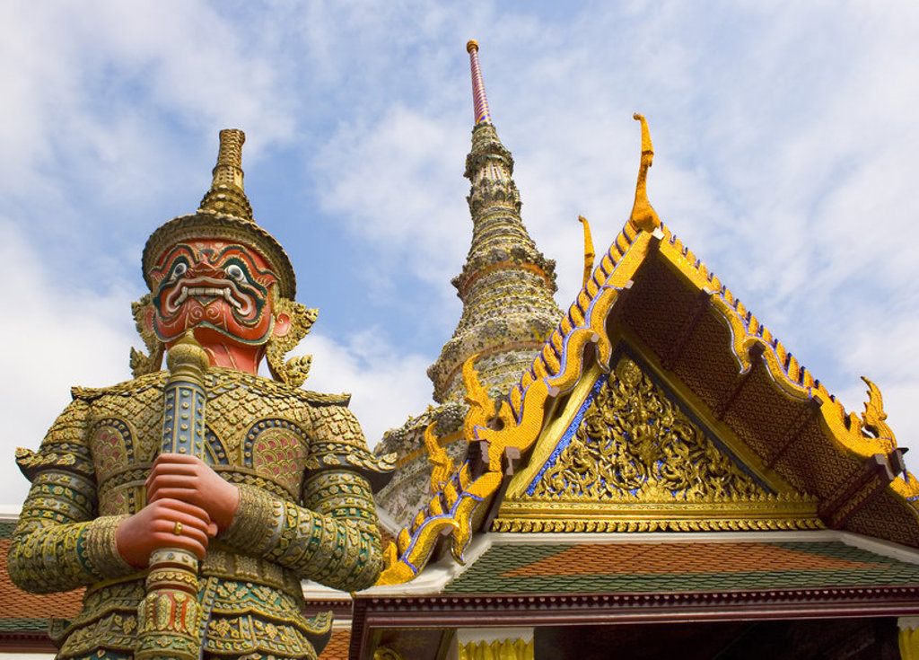 Gouden tempelwachter en pagode bij een Thaise tempel, hoogtepunten van een familiereis door Thailand.