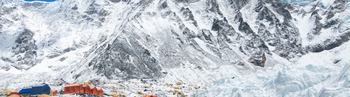 Kleurrijk tentenkamp bij Everest Base Camp, met besneeuwde Himalayareuzen en Khumbu-gletsjer op de achtergrond.
