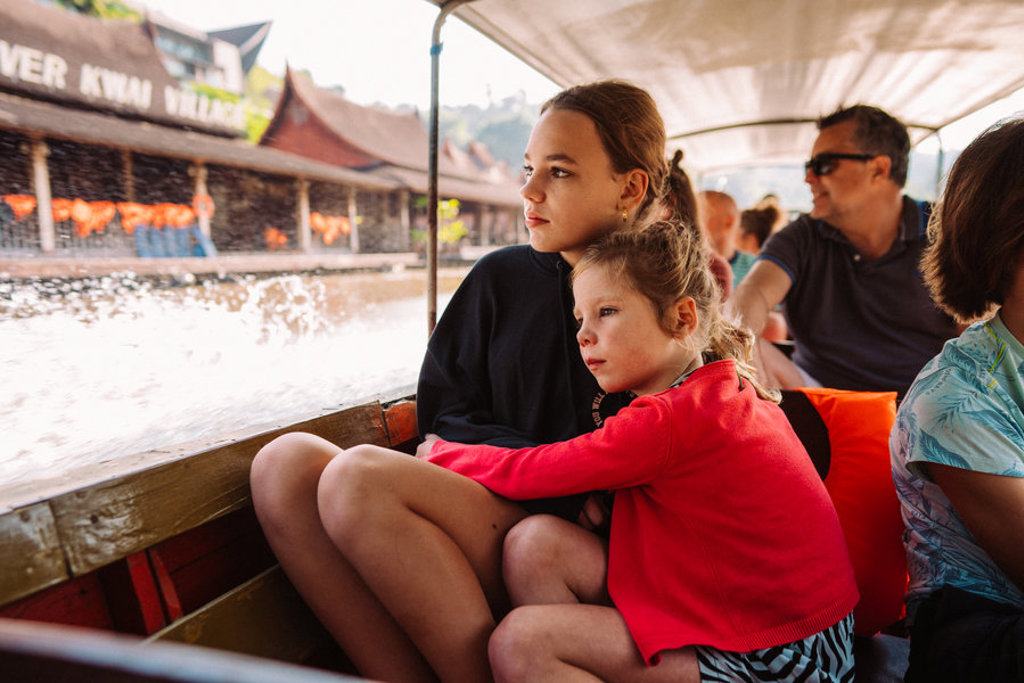 Moeder en kind varen in een longtailboot langs de drijvende markt in Thailand tijdens familiereis Chill & Adventure.