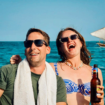 Jonge reizigers lachen op een boot op zee tijdens 22-35ers reis Kenia & Tanzania.