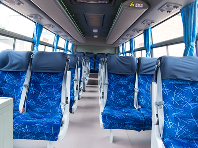 Interieur van een touringcar met blauwe stoelen, gebruikt voor vervoer in Zuid-Afrika.