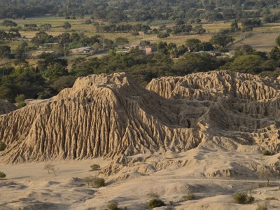 Erosielandschap met zandkleurige rotsformaties en groene vallei langs de route Noord-Peru.