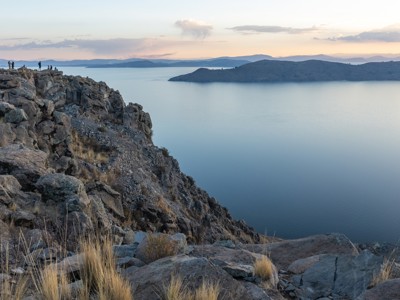 Uitzicht vanaf rotsachtige kliffen over het Titicacameer in Peru bij zonsondergang.