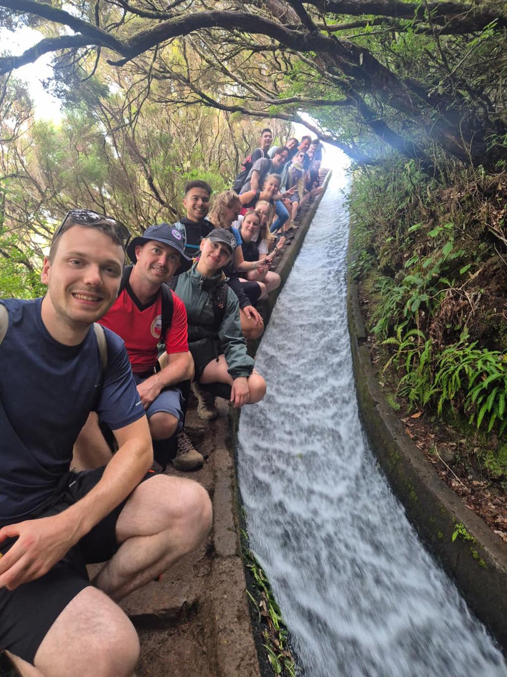 Jonge reizigers wandelen met rugzakken door groen berglandschap op Madeira, Portugal.