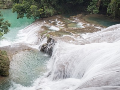 Watervallen met turquoise water in weelderig groen langs de Route Ruta Maya.