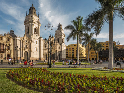 Plaza Mayor in Lima met de kathedraal, palmbomen en kleurrijke bloemperken tijdens een groepsrondreis Peru.