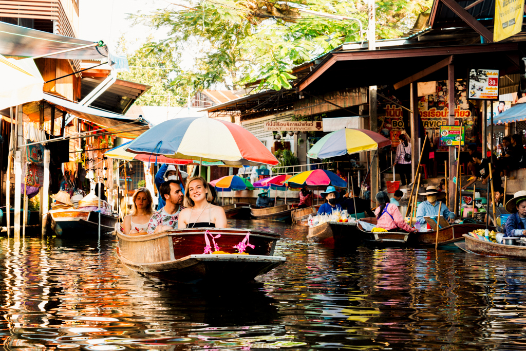 Groepsrondreis Thailand: boottocht over de drijvende markt met kleurrijke parasols.